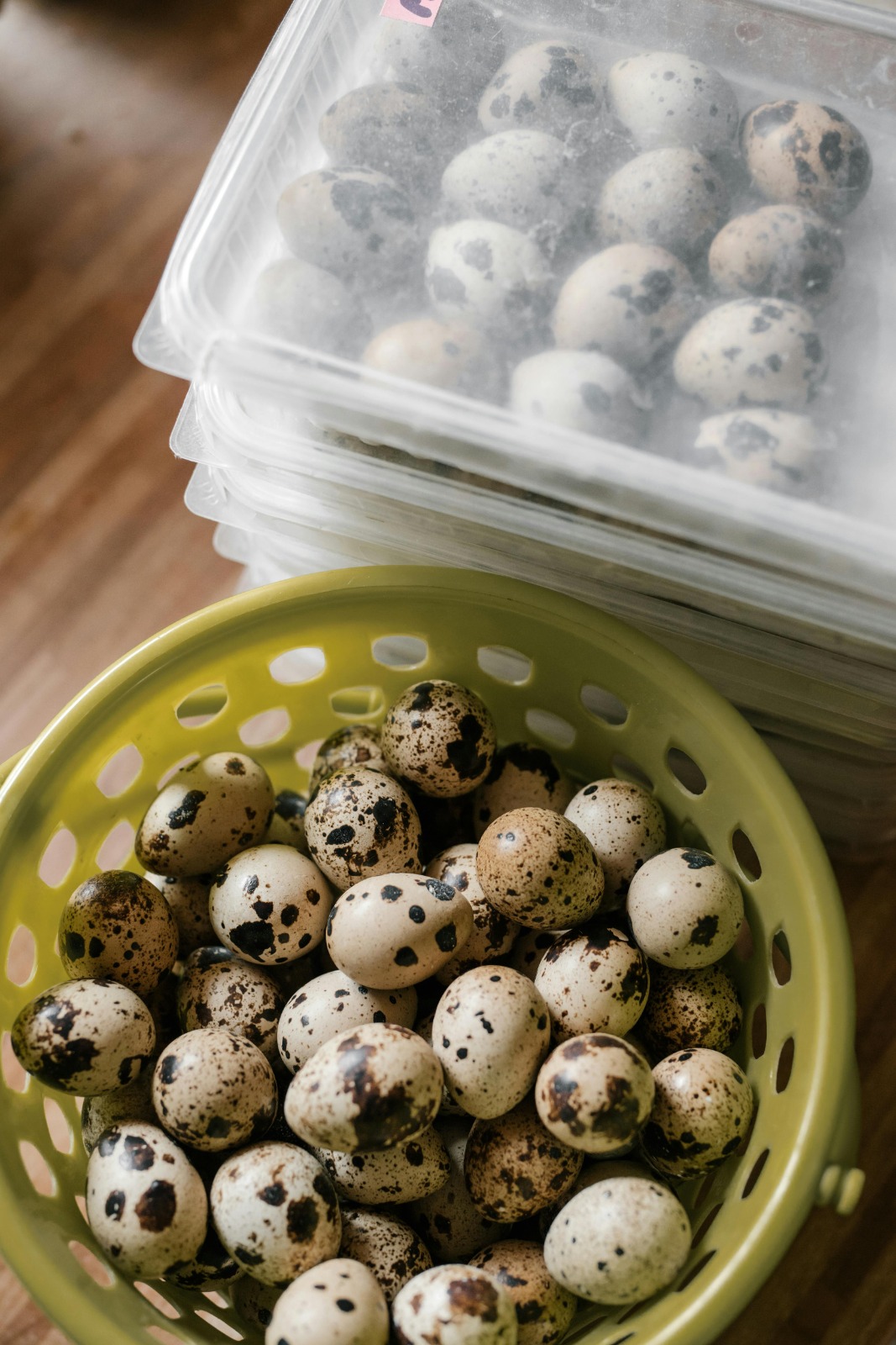 Fresh speckled quail eggs in a terracotta bowl